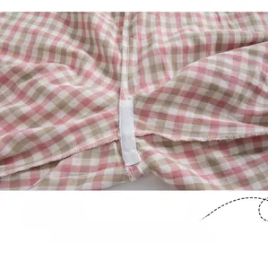 Vue détaillée de l'entrejambe renforcé avec bande de sergé blanc sur un pantalon à carreaux