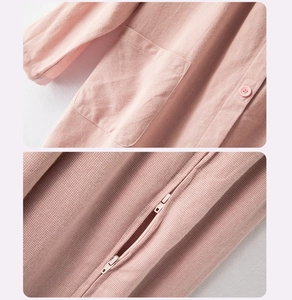 Detailed pink waffle fabric of patient care apparel showing side pocket and two-way zippers