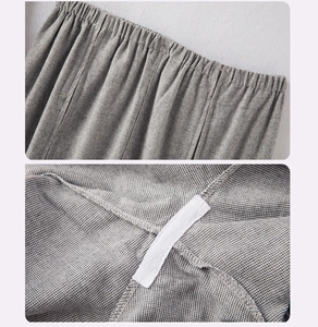 Detail of the elastic waistband and reinforced inner stitching on gray checkered flannel pants