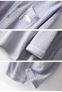 Detailed view of embroidery, wooden buttons, and white piping on cotton pajamas