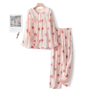 Pink cotton pajamas set with peach prints and lace trim on wood hanger with clean background