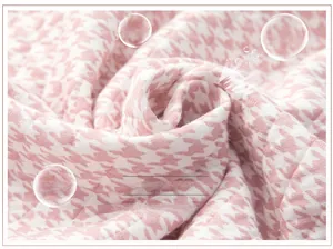 Dettaglio ravvicinato di tessuto in cotone trapuntato rosa con motivo pied-de-poule