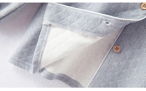 Detail of grey herringbone fabric with quilted lining and natural wooden buttons