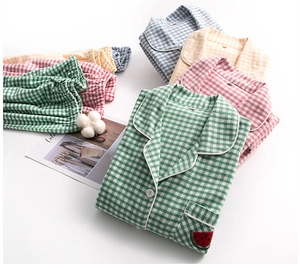 Detail of cotton plaid pajamas featuring fruit embroidery and contrasting piped edges