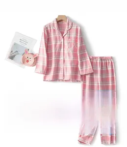 Detail of pink plaid brushed cotton pajamas for girls with white buttons and piping finish