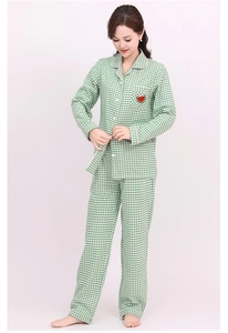 Detail view of cotton pajama set showing green plaid pattern and watermelon embroidery