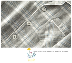 Close-up of brushed cotton plaid fabric with white piping and round grey buttons