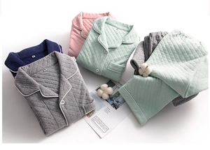 Flat lay of quilted cotton pajamas in gray pink green and navy with cotton props