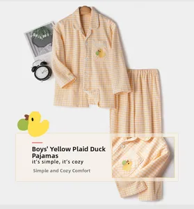 Détail d'un pyjama enfant à carreaux jaunes avec broderie canard et fermeture boutonnée
