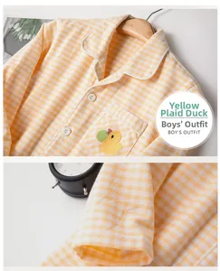 Détail d'un pyjama enfant à carreaux jaunes avec broderie canard et tissu en coton doux