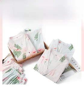 Detail view of pink and blue cotton flamingo pajamas set with a palm leaf pattern