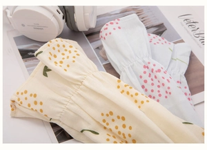 Close-up of cotton sleeve protectors featuring polka dot and floral patterns on desk