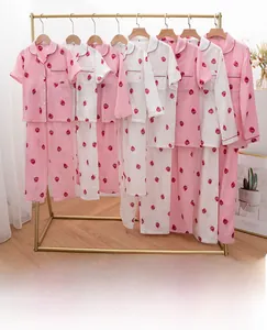 Detail view of cotton pajama sets with red strawberry prints on pink and white fabric