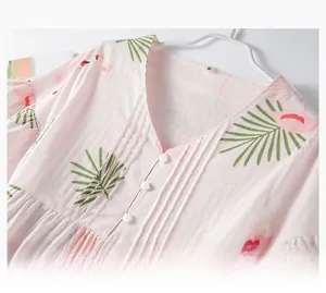 Détail du col en V avec boutons et imprimé flamant rose sur chemise de nuit en coton