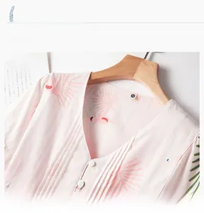 V-neck detail of pink flamingo print pajamas with cotton ruffle and white buttons