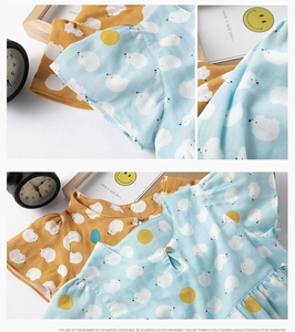 Détail d'un pyjama en coton avec imprimés d'ours polaires et bouton en bois naturel