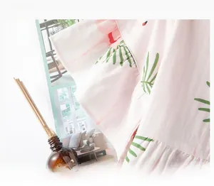 Detail of ruffle sleeve cuff on light pink cotton pajama featuring tropical leaf prints