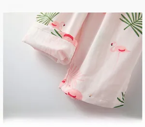 Detail of neatly stitched cuffs on pink cotton pajamas with flamingo and leaf prints