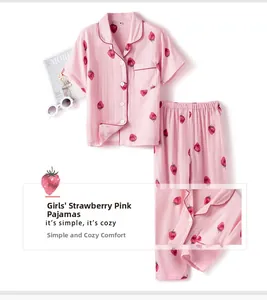 Detail of pink cotton gauze kids pajamas set featuring red strawberry prints and buttons