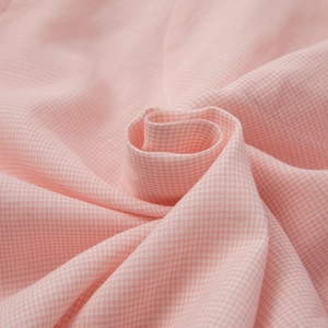 Pink houndstooth cotton pajama fabric detail showing soft texture and fine grid weave