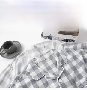 Close-up of cotton plaid pajamas set with buttons and size tags on a white background