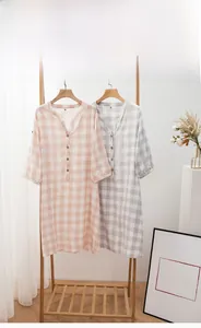 Dettaglio dello scollo a V e bottoni in legno su camicia da notte in cotone