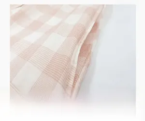 Dettaglio della tasca laterale su una camicia da notte in cotone a quadretti rosa