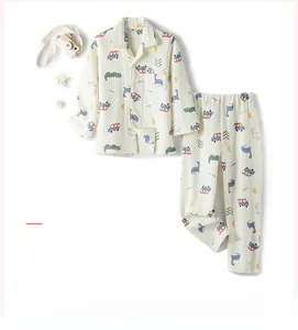 Détail d'un pyjama pour garçons blanc crème avec motifs de dinosaures et de voitures