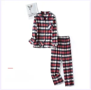 Détail d'un pyjama en coton à carreaux rouges pour femme avec haut à manches longues boutonné