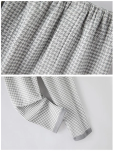 Detail of houndstooth pajama pants showing elastic waistband and dark grey hemmed cuffs