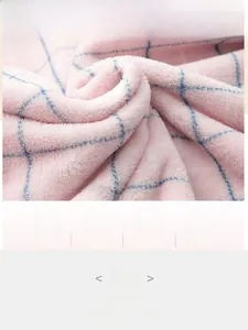 Détail du tissu polaire corail à carreaux rose et bleu montrant une texture douce