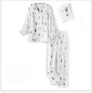 Detail view of cotton pajama set featuring green potted plant prints and ruffle collar