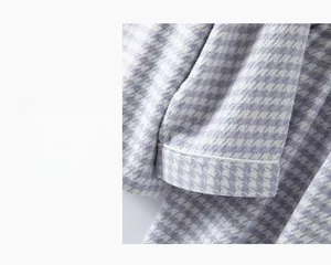 Détail d'un pyjama en coton à carreaux lilas montrant le poignet droit avec liseré blanc