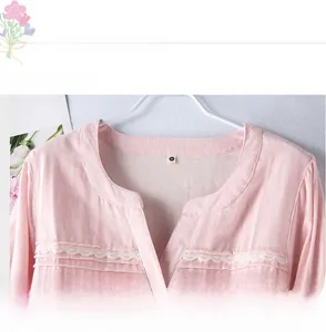 Detail of pink cotton nightgown with V-neckline, white lace trim and pleated texture