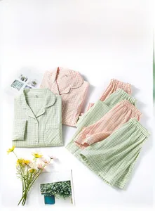 Flat lay of breathable gingham cotton pajamas in mint green and soft pink colors