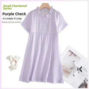 Détail de robe en coton à carreaux violets avec col à volants et dentelle fine