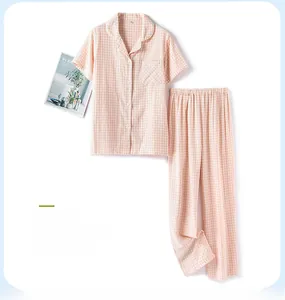 Pink checkered cotton short sleeve pajama set laid flat with cozy home decor magazine
