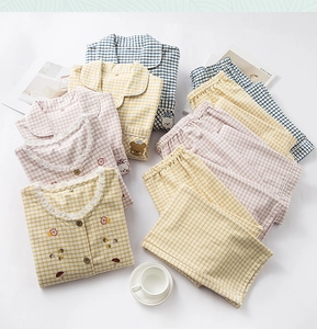 Detail of neatly folded checkered cotton pajamas with cute animal and plant embroidery