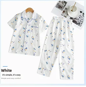 Détail d'un pyjama en coton blanc pour garçons avec imprimé excavatrice bleue