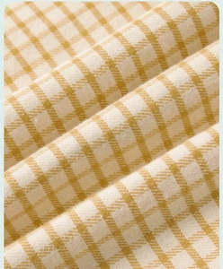 Close-up of yellow and white checkered cotton fabric with thick woven texture for pajamas