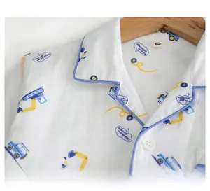 Détail du haut de pyjama en coton pour garçon avec motif pelleteuse et col à revers