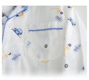 Détail de la poche de pyjama en coton avec motifs d'excavatrices bleues et liseré