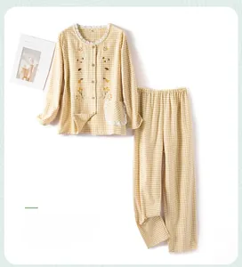 Detail of yellow checkered cotton pajamas featuring lace collar and floral embroidery