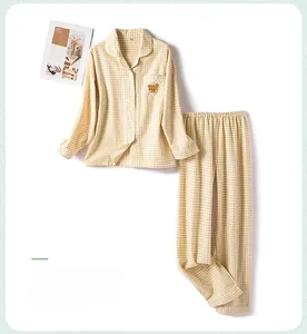 Flat lay of yellow plaid cotton pajamas set with cute bear embroidery and simple cozy style