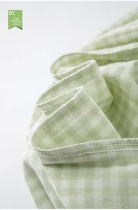 Detail showing overlocking seams and soft light green plaid cotton fabric