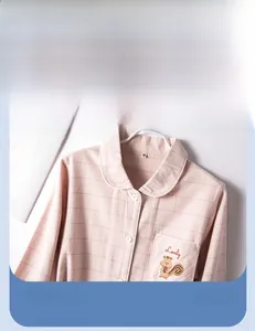 Détail d'un pyjama à carreaux roses avec col classique et broderie d'écureuil
