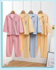Detail der Tierbestickung und des Gingham-Musters auf Baumwoll-Kinderpyjamas