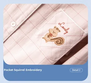 Détail de la broderie écureuil et texte 'Lovely' sur le pyjama à carreaux rose