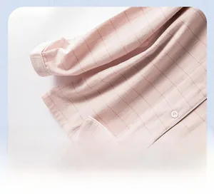 Gros plan détaillé du revers de pyjama à carreaux roses avec passepoil et boutons en perles