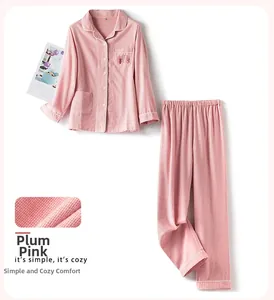Dettaglio del pigiama in cotone a scacchi rosa prugna con texture e piping bianco